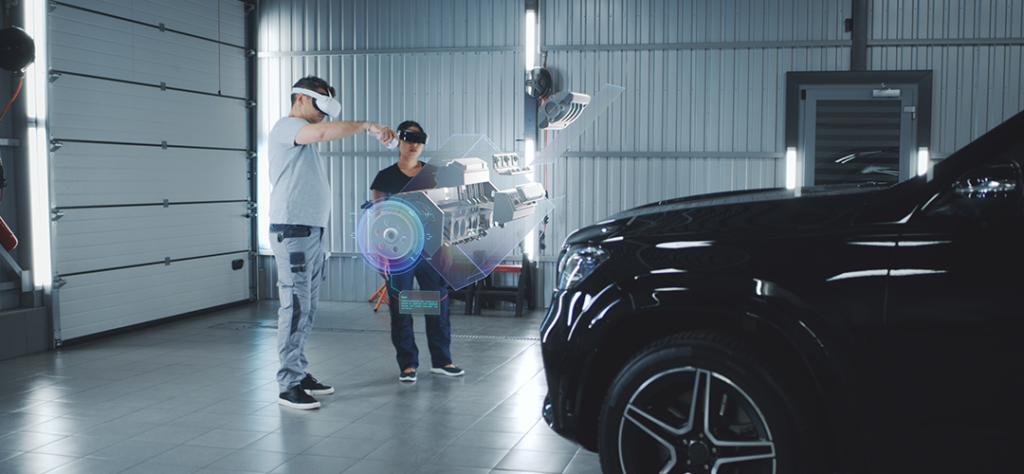Zwei Ingenieure nutzen Augmented Reality zur Visualisierung und Interaktion mit einem virtuellen Fahrzeugmotor in einer modernen Autowerkstatt, mit einem schwarzen Auto im Hintergrund.